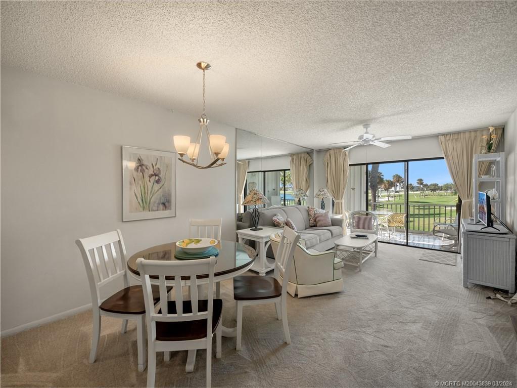 484 Northeast Plantation Road, Unit 4106 Jensen Beach, FL 34957 - Photo 5 of 15 a dining room with furniture a chandelier and window