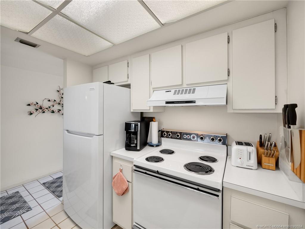 484 Northeast Plantation Road, Unit 4106 Jensen Beach, FL 34957 - Photo 8 of 15 a white refrigerator freezer sitting inside of a kitchen