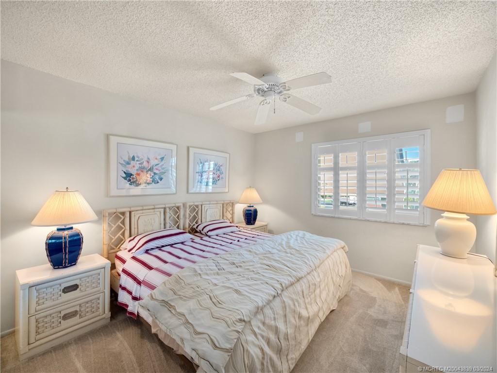 484 Northeast Plantation Road, Unit 4106 Jensen Beach, FL 34957 - Photo 9 of 15 a bedroom with a bed and a window
