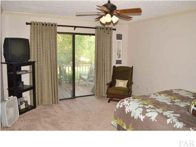 8801 Burning Tree Road Pensacola, FL 32514 - Photo 13 of 24 The master bedroom is quite large with double glass sliding doors onto the open deck,