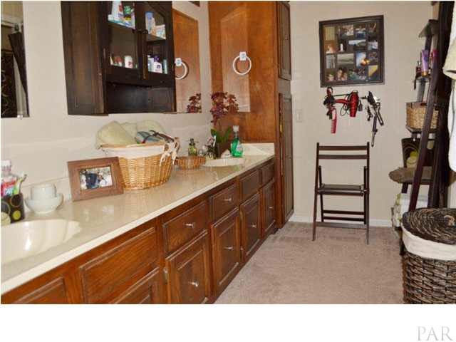 8801 Burning Tree Road Pensacola, FL 32514 - Photo 15 of 24 The master bath has ample dressing space with extra-long double vanity, walk-in closet and custom cabinetry.