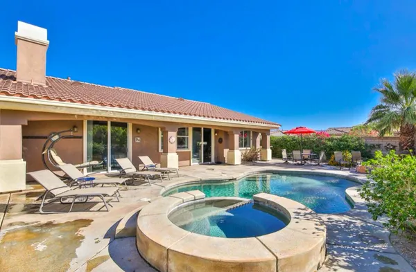 a view of a house with swimming pool and sitting area