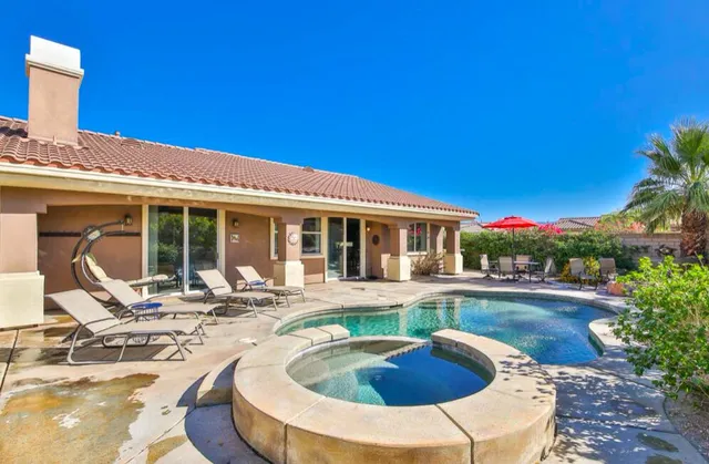 a view of a house with swimming pool and sitting area