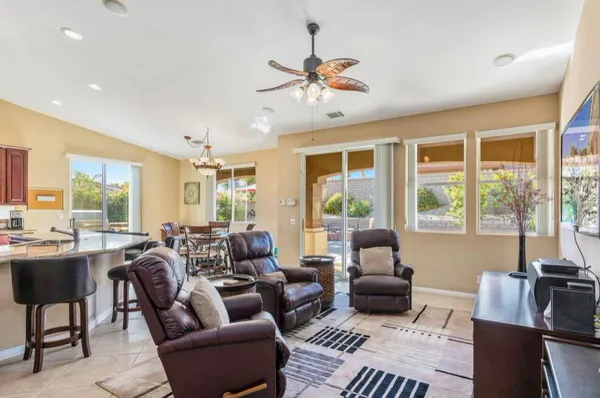 a kitchen with stainless steel appliances kitchen island granite countertop a dining table chairs and a refrigerator