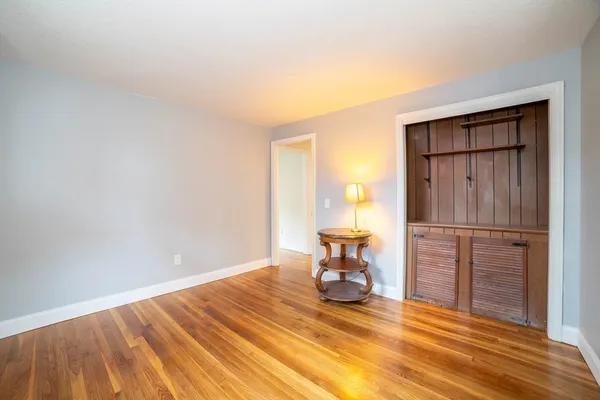 a view of a livingroom with wooden floor and furniture