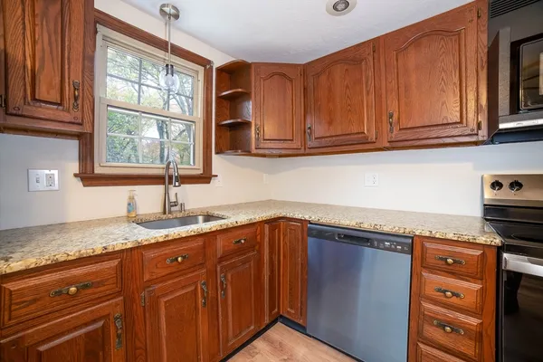 a kitchen with granite countertop cabinets sink and window