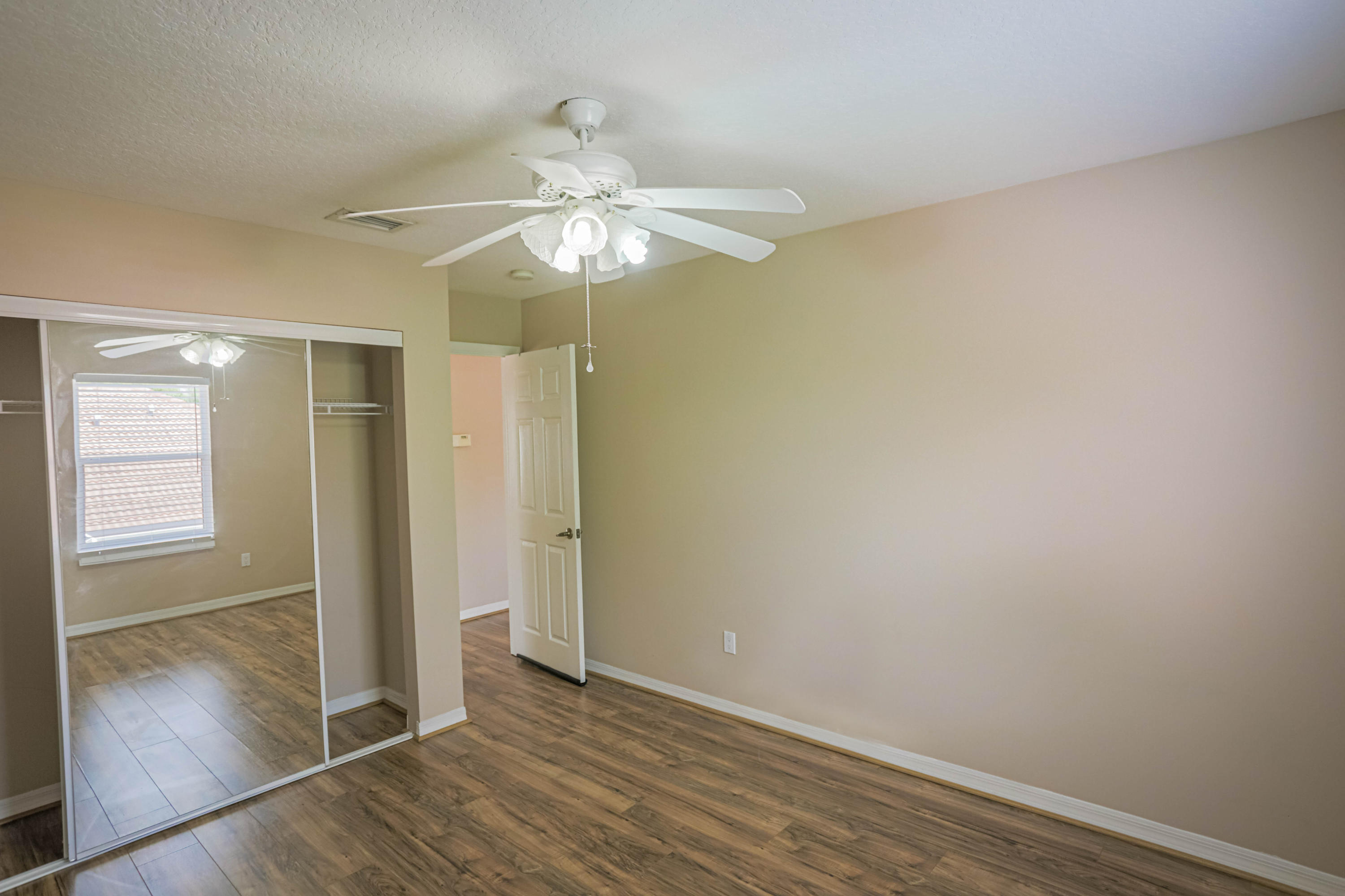 5218 Edenwood Road Riviera Beach, FL 33418 - Photo 16 of 31 an empty room with wooden floor fan and windows
