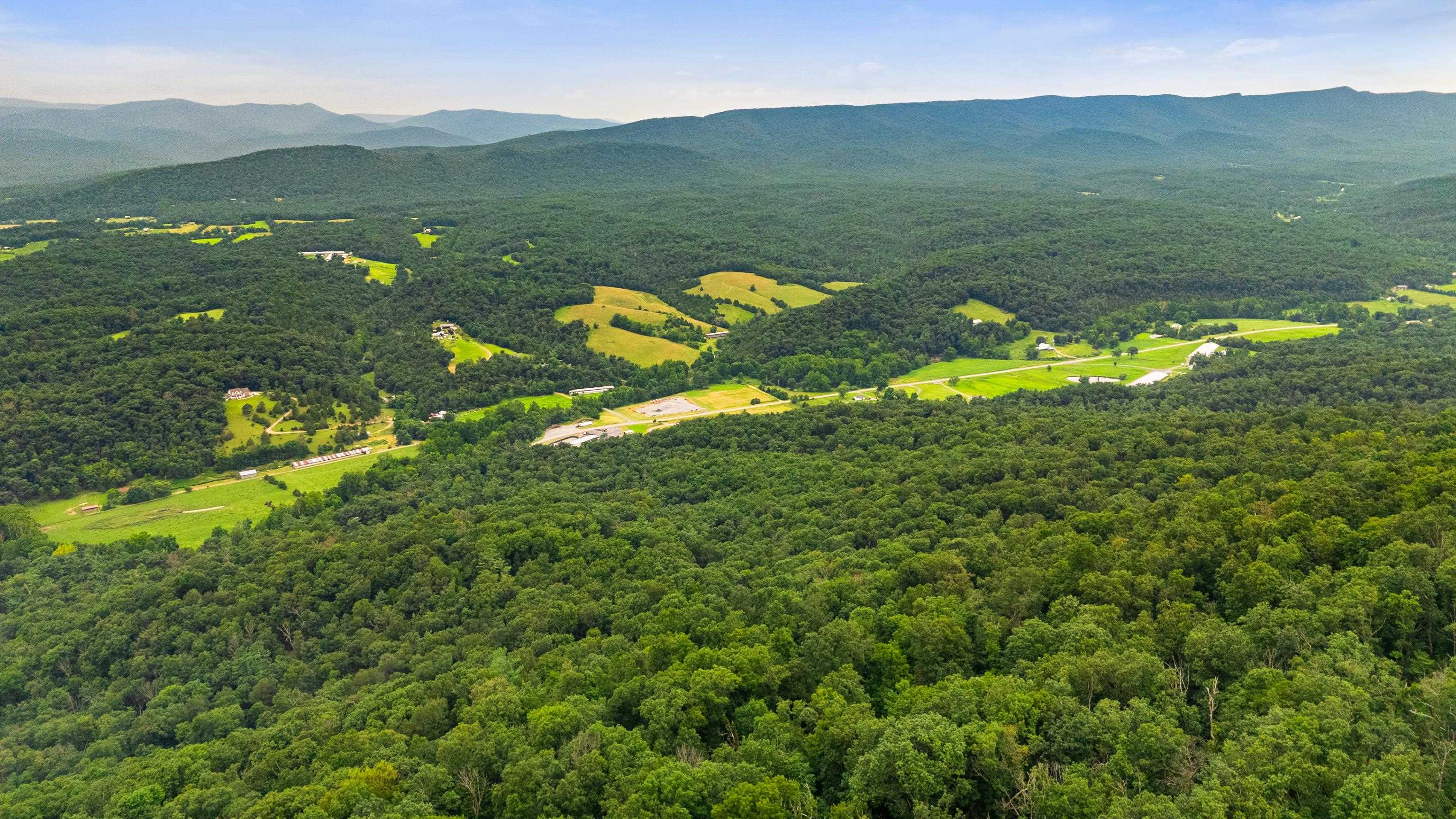198-acres Runions Creek Road Broadway, VA 22815 - Photo 36 of 60 a view of a lush green hillside and a houses
