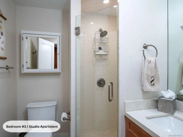 a living room with furniture kitchen view and a wooden floor