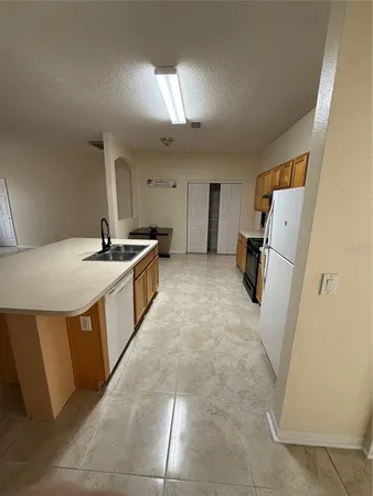 a kitchen with a sink a refrigerator and a stove