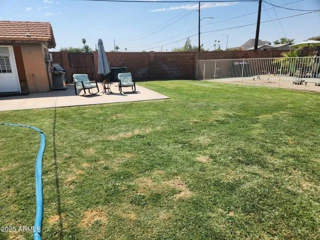 a view of a house with backyard and sitting area