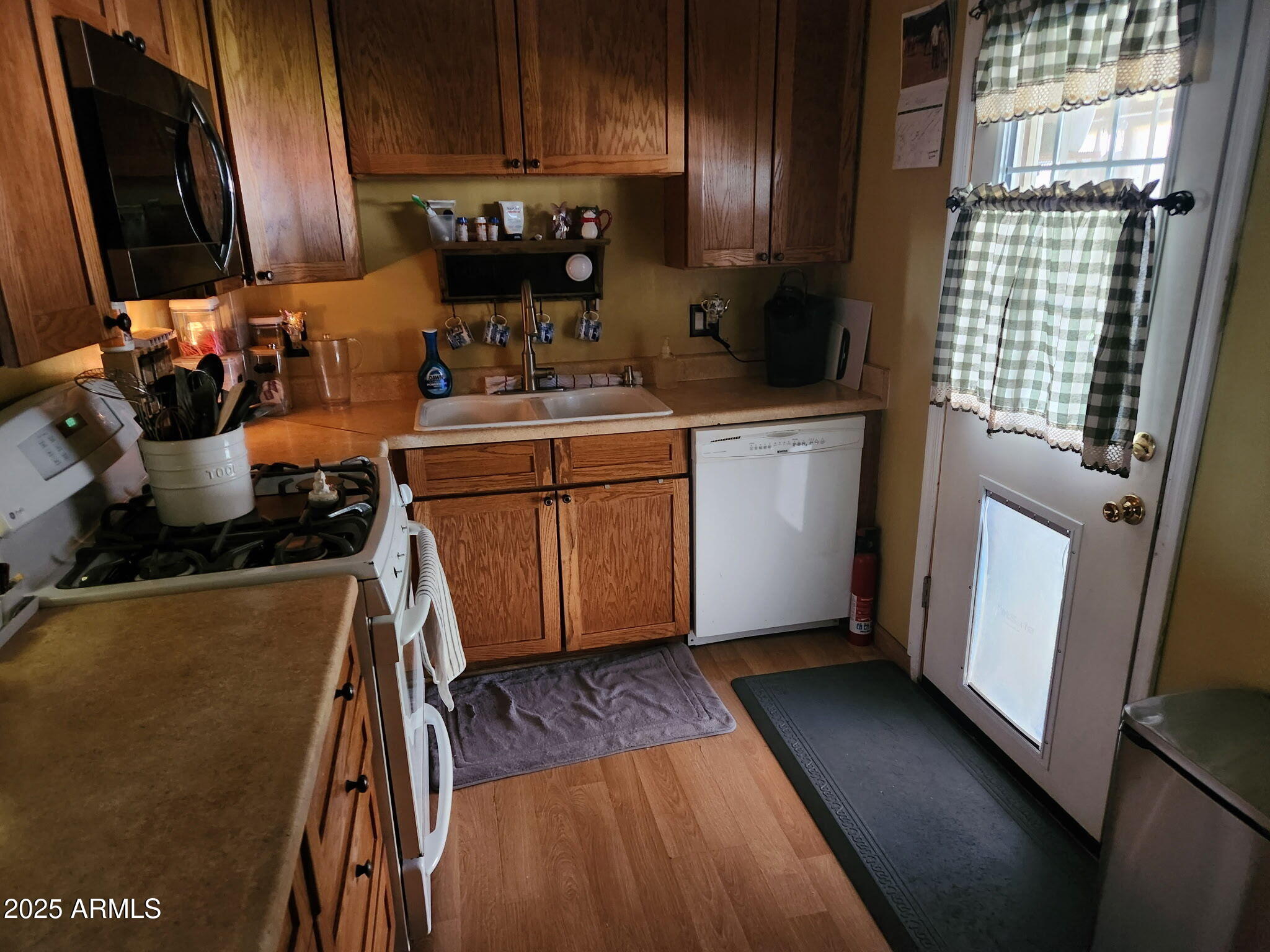 3039 East Cactus Road Phoenix, AZ 85028 - Photo 9 of 15 a kitchen with a refrigerator wooden floor and a stove top oven
