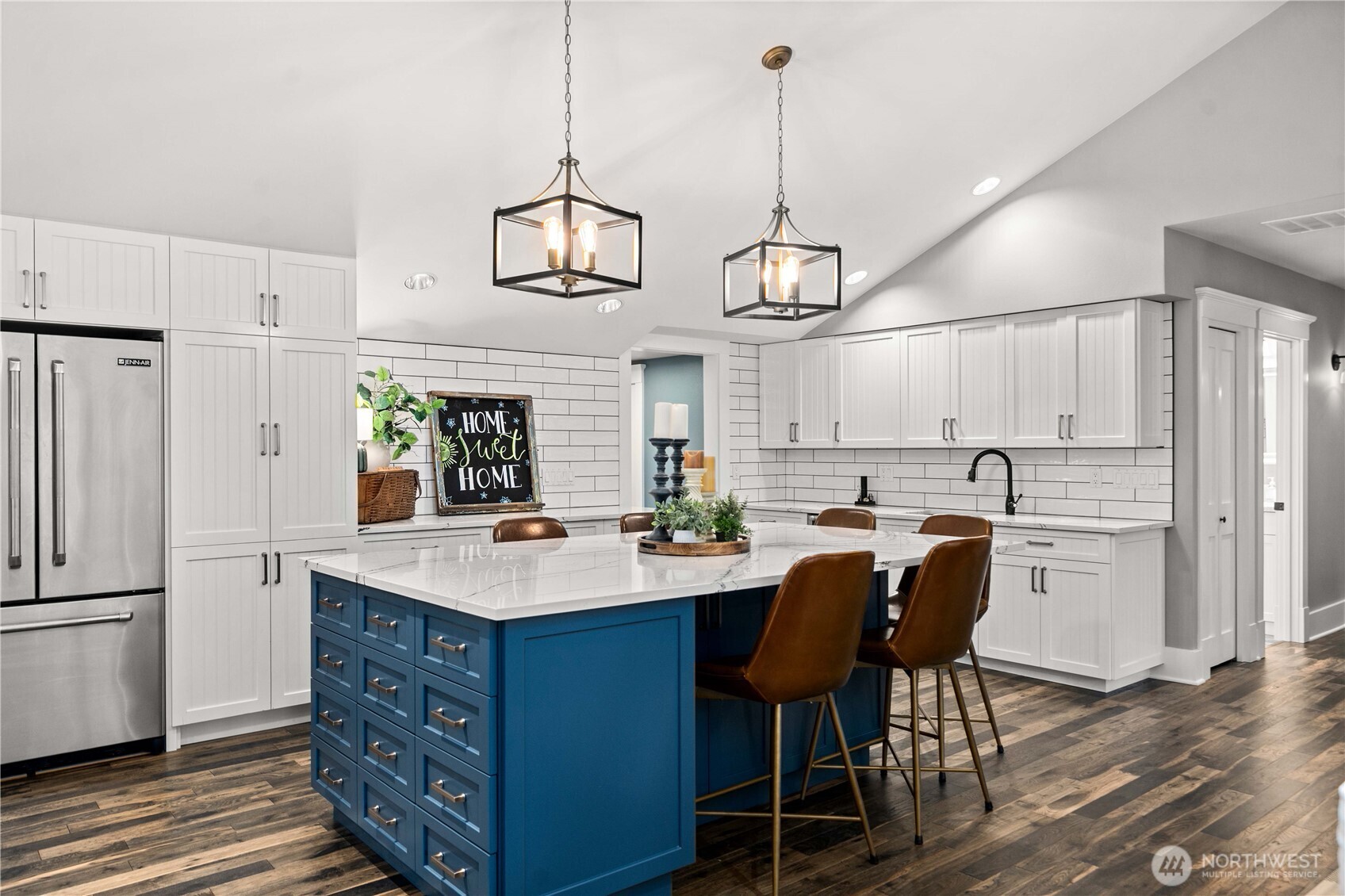 26002 Southeast 208th Street Maple Valley, WA 98038 - Photo 9 of 40 a kitchen with stainless steel appliances kitchen island granite countertop a table chairs and a refrigerator