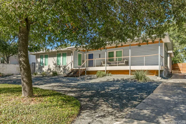a view of a house with backyard and sitting area