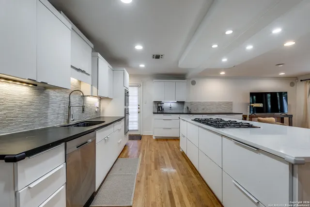 a large kitchen with stainless steel appliances kitchen island granite countertop a stove a sink and a refrigerator