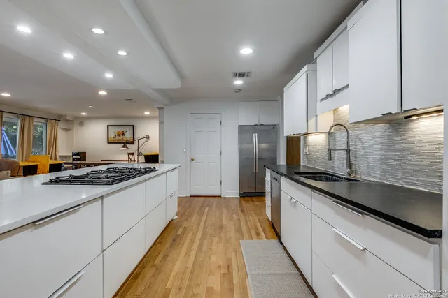 a large kitchen with stainless steel appliances granite countertop a lot of counter space a sink and a stove