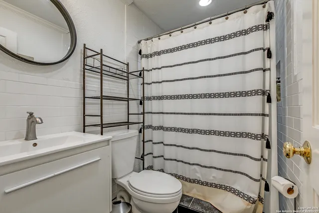 a bathroom with a toilet and a mirror