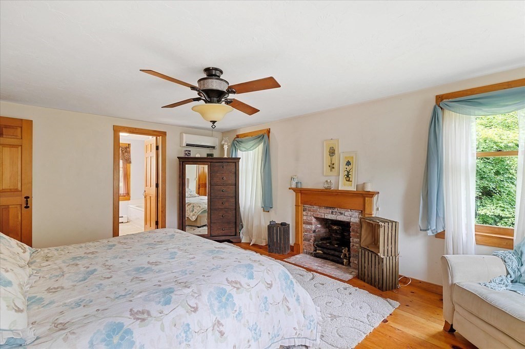 94 Stallion Hill Road Sturbridge, MA 01518 - Photo 23 of 42 a bedroom with a bed and a fireplace