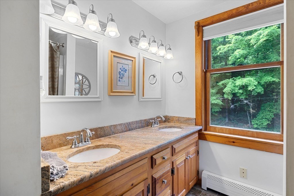 94 Stallion Hill Road Sturbridge, MA 01518 - Photo 27 of 42 a bathroom with a granite countertop sink and a large mirror