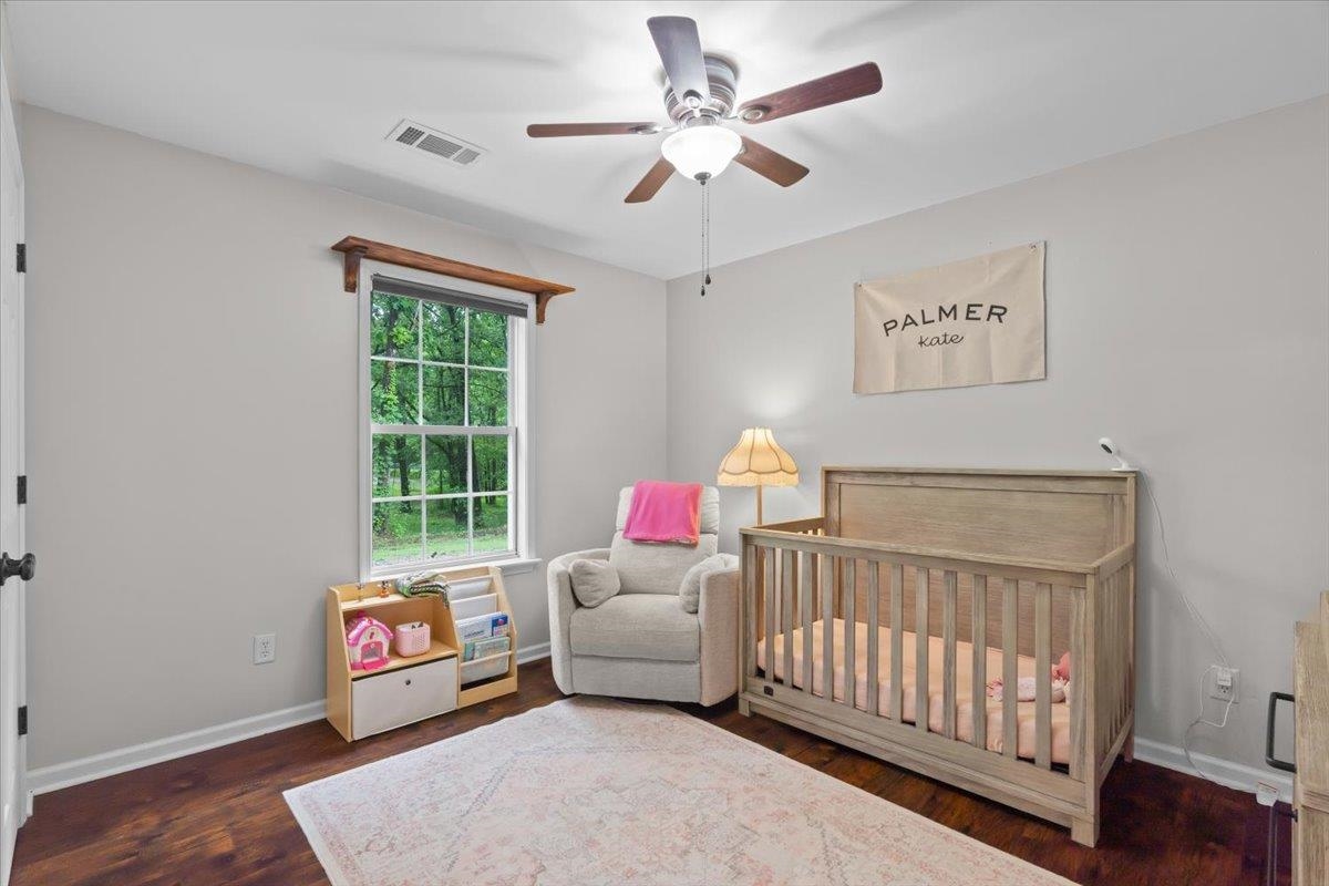 150 Liberty Road Moscow, TN 38057 - Photo 13 of 36 Bright interior room featuring a ceiling fan with integrated lighting, wood-finish flooring, and a window with a wooded backdrop