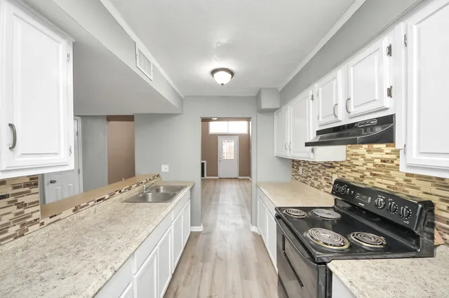 a kitchen with granite countertop a stove and a sink