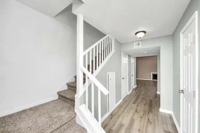 a view of a hallway with wooden floor and entryway