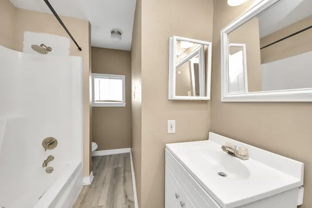 a bathroom with a sink a window and shower