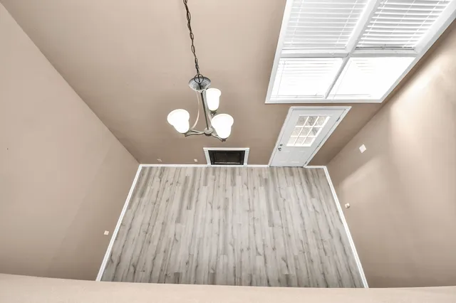 a view of a room with wooden floor fan and window