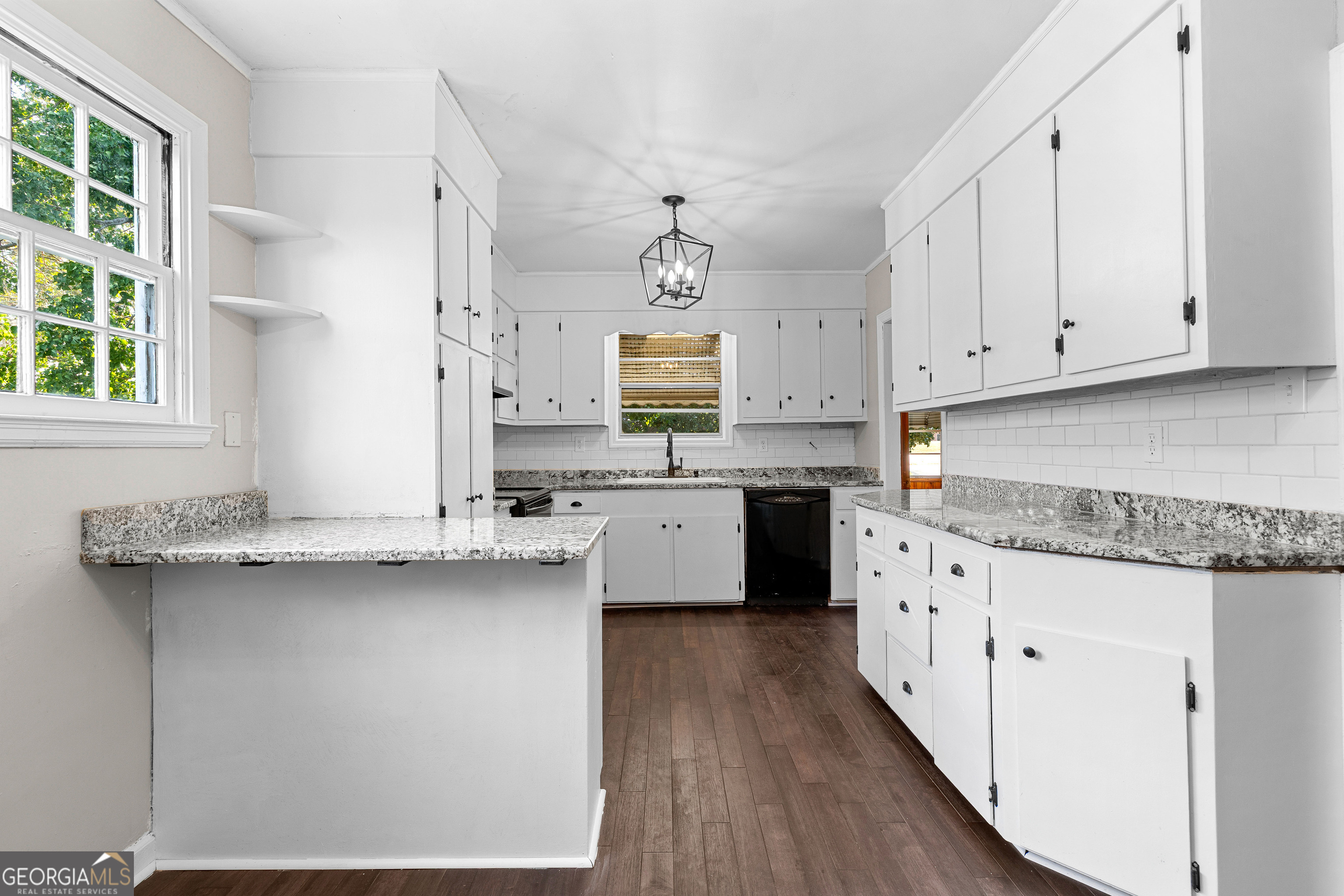 213 N Street Southwest Thomaston, GA 30286 - Photo 18 of 38 a kitchen with granite countertop a sink cabinets stainless steel appliances and a window