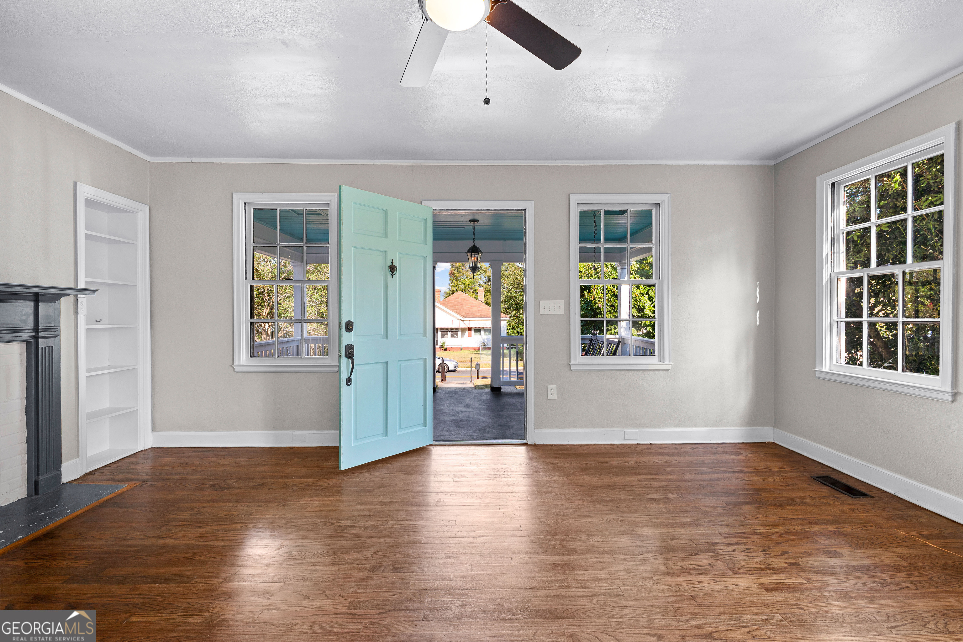 213 N Street Southwest Thomaston, GA 30286 - Photo 6 of 38 an empty room with wooden floor and windows