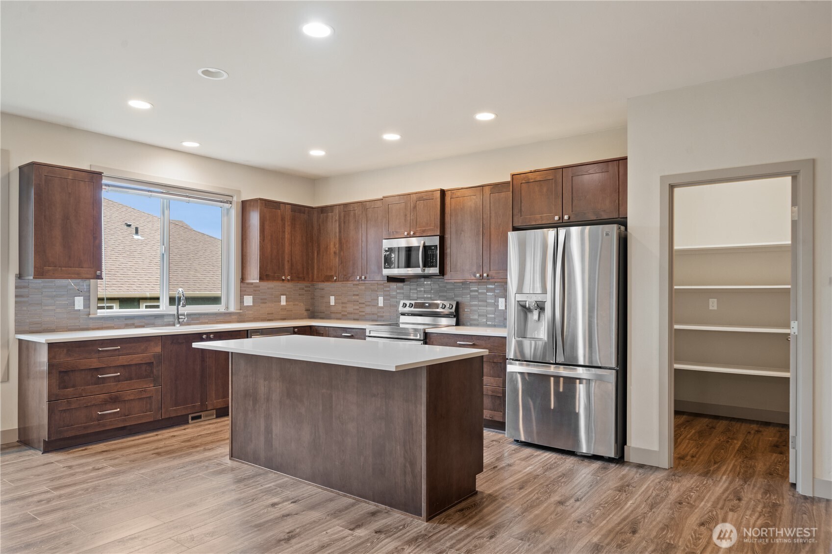 200 Blue Glacier Loop Sequim, WA 98382 - Photo 18 of 39 a kitchen with stainless steel appliances granite countertop a stove a refrigerator and a sink with wooden cabinets