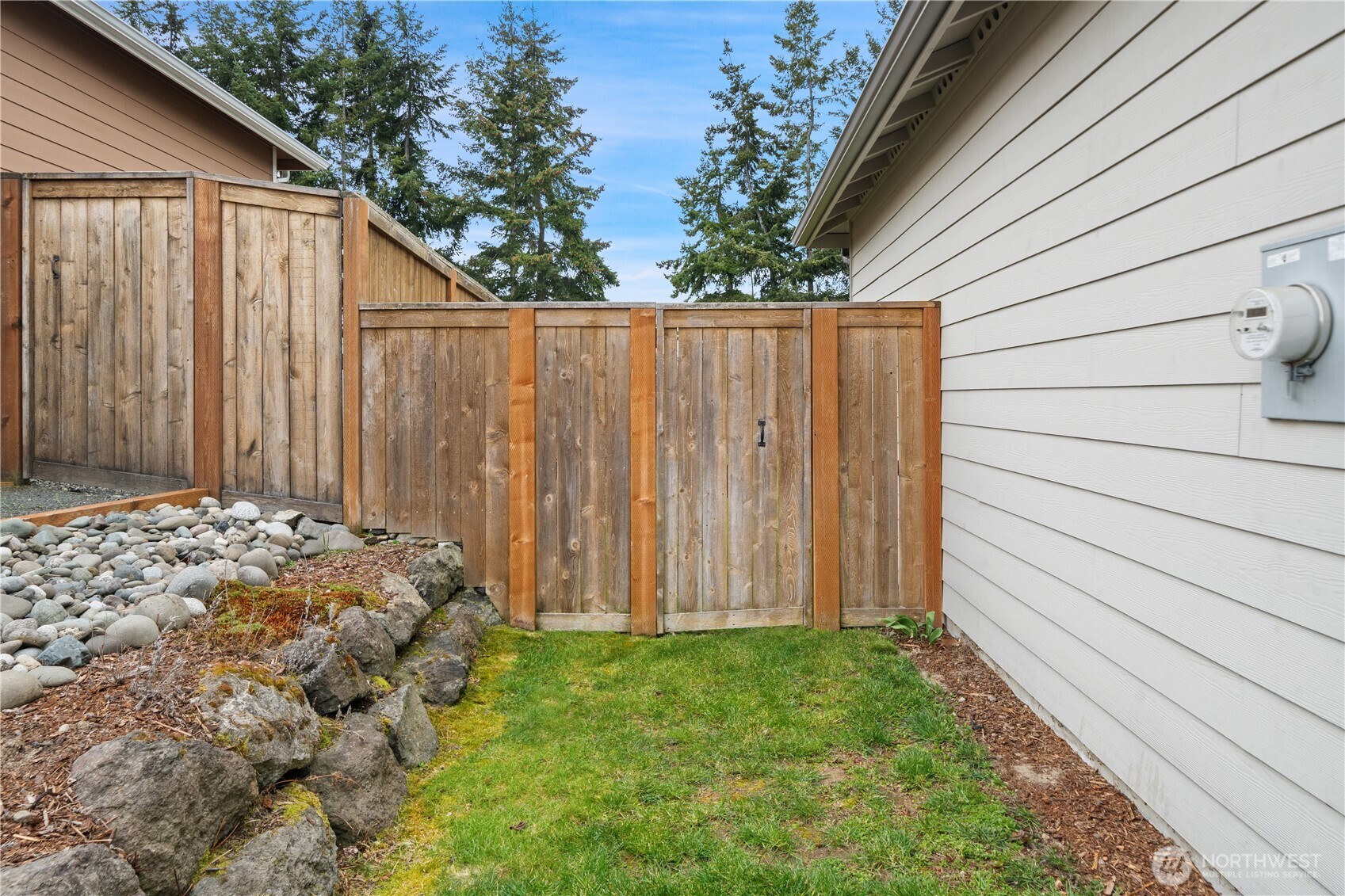 200 Blue Glacier Loop Sequim, WA 98382 - Photo 35 of 39 a view of a backyard with potted plants and wooden fence