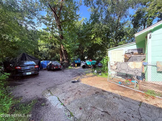 a view of backyard with a table and chairs under an umbrella