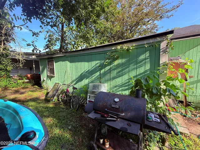 a backyard of a house with barbeque oven and outdoor seating