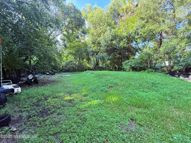 a view of a yard with a house in the background