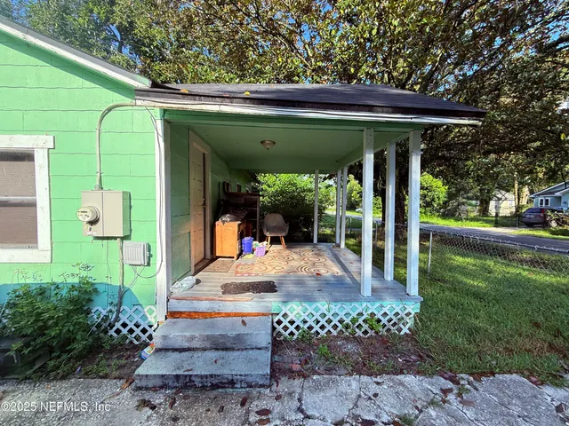 a view of a porch with a table and chairs
