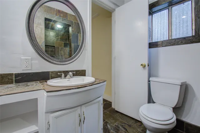 a bathroom with a toilet a sink and a mirror