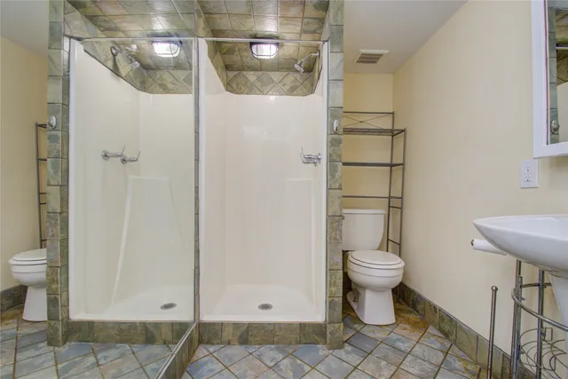 a bathroom with a toilet and a shower