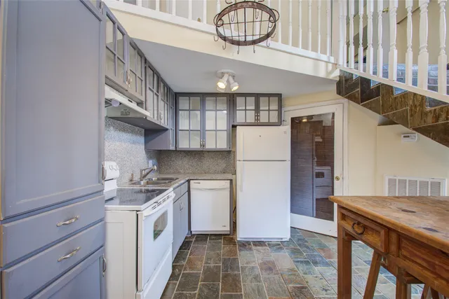 a kitchen with stainless steel appliances granite countertop a sink a stove cabinets and entryway