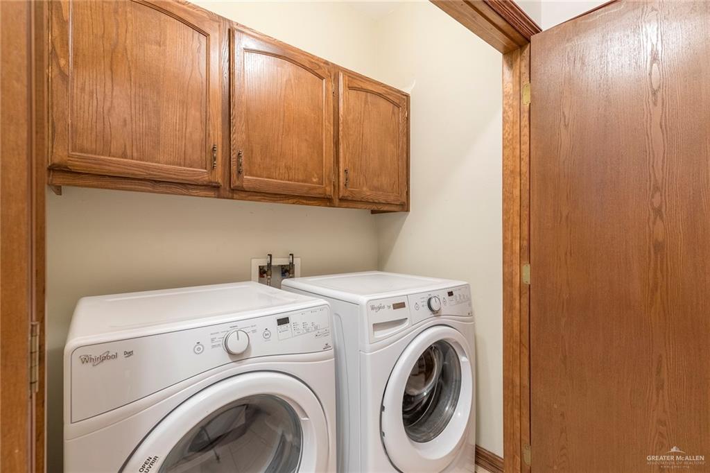 1213 Rhett Drive Pharr, TX 78577 - Photo 16 of 19 Laundry room with upper storage cabinets and front-loading washer and dryer.
