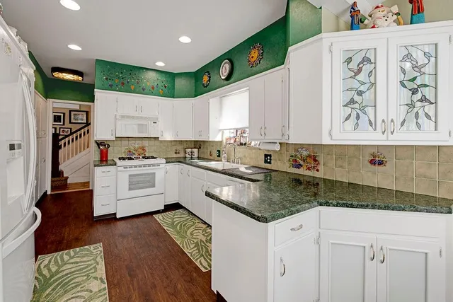 a kitchen with granite countertop white cabinets and white appliances