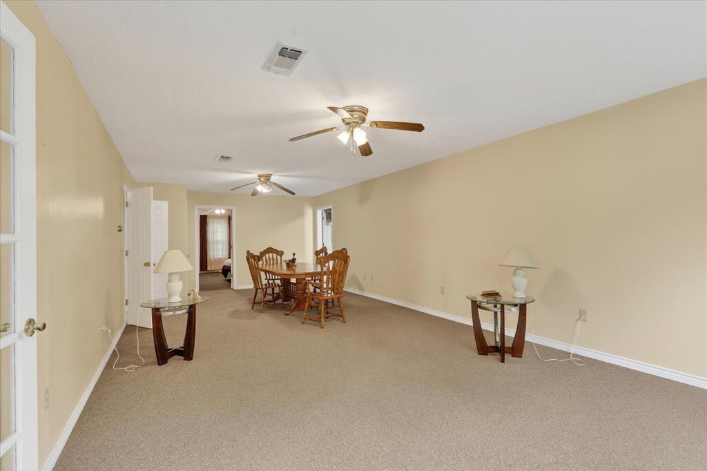1092 West Highway 199 Springtown, TX 76082 - Photo 7 of 29 Spacious living area featuring neutral carpet flooring and light-toned walls and ceiling fans