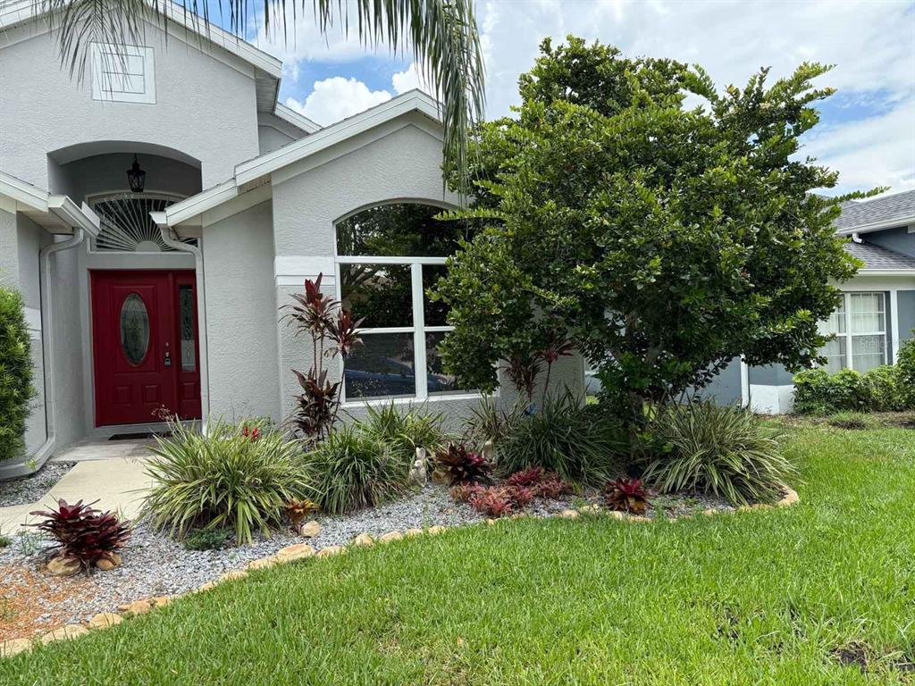 4124 Beaumont Loop Spring Hill, FL 34609 - Photo 1 of 1 a front view of house with yard and outdoor seating