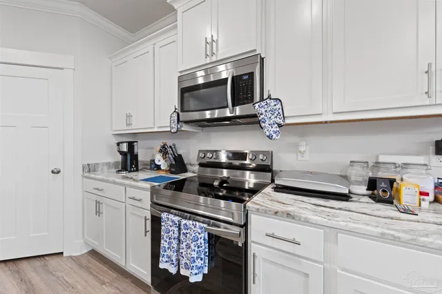 a kitchen with stainless steel appliances granite countertop a sink a stove and a microwave