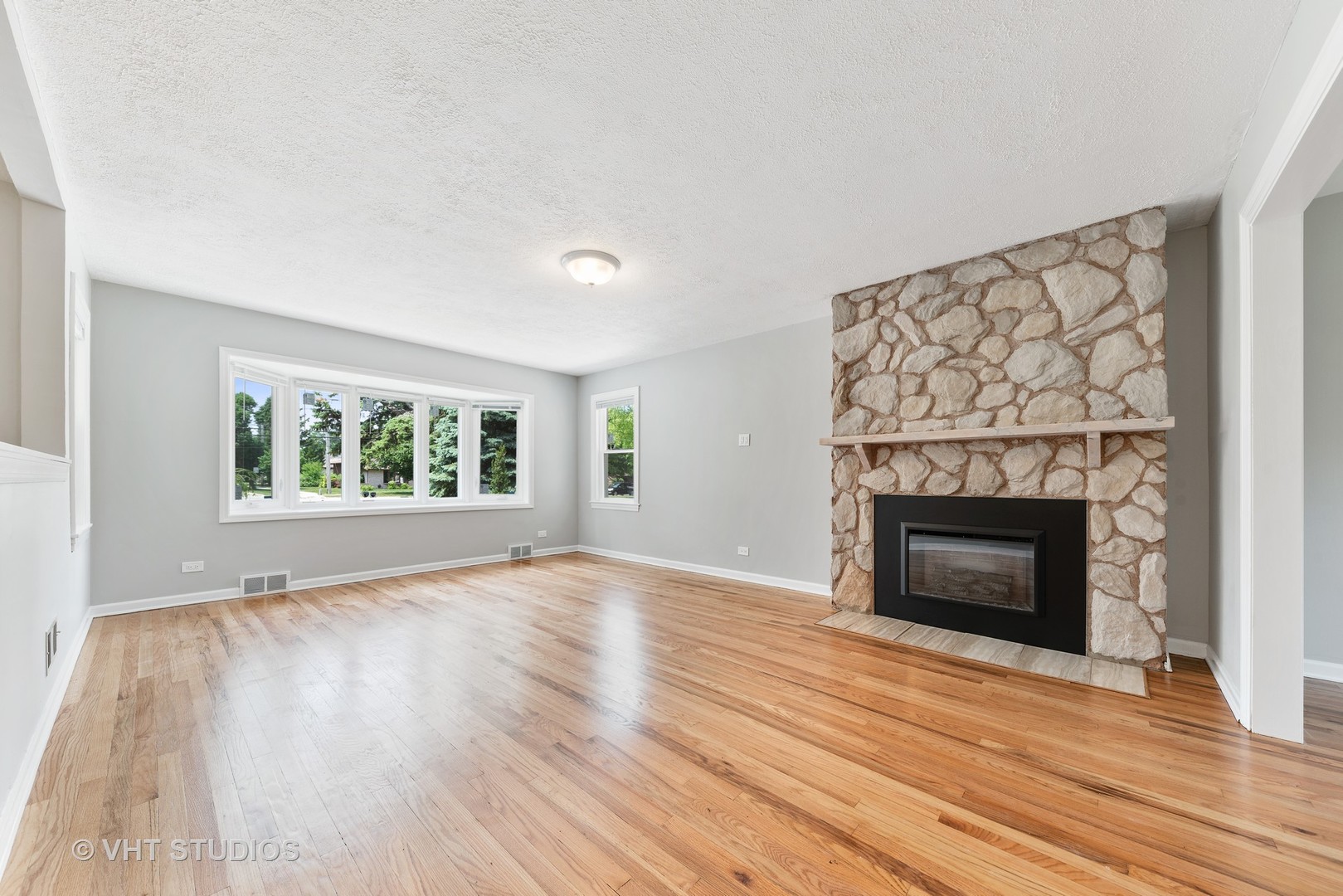 307 North Westgate Road Mount Prospect, IL 60056 - Photo 7 of 17 an empty room with wooden floor fireplace and windows