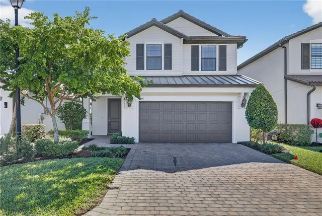 a front view of a house with a garden and garage