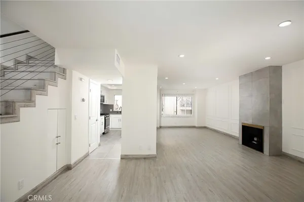 a view of empty room with wooden floor and fireplace