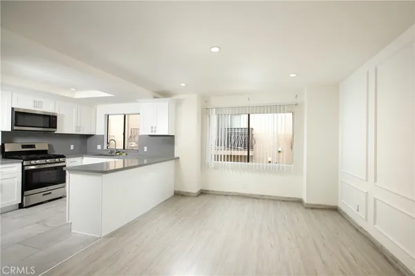 a large kitchen with stainless steel appliances granite countertop a lot of counter space and wooden floor