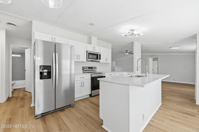 a kitchen with stainless steel appliances a sink stove and cabinets