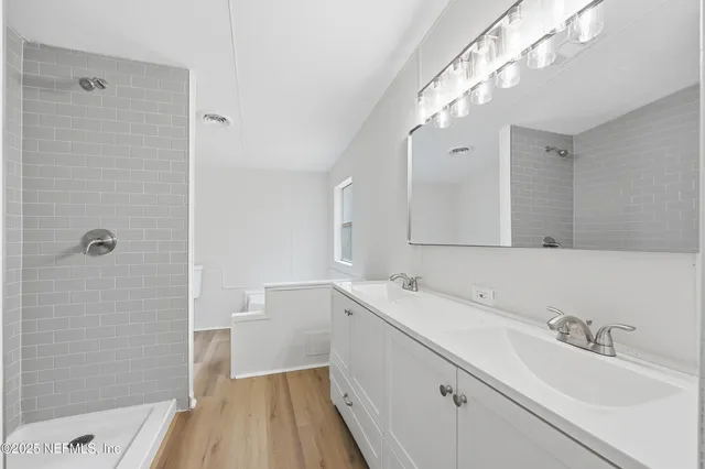 a bathroom with a sink a shower and a mirror